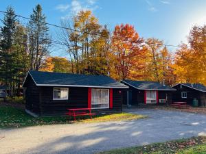 ein kleines Haus mit einer roten Bank davor in der Unterkunft Glenview Cottages in Sault Ste. Marie