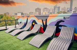 four chairs in front of a wall with a mural at Nate's Place Backpackers Sydney in Sydney