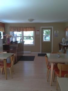 a dining room with tables and chairs and a door at Wildwood Motel in Shelburne