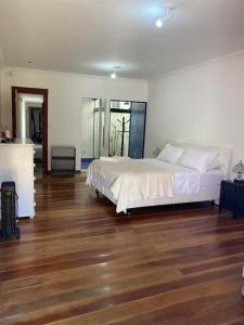 um quarto com uma cama grande e piso em madeira em Solar Antônio Dias em Ouro Preto