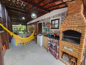 uma cozinha com uma lareira de tijolos e uma área de refeições em Lindo chalé completo para até 10 pessoas com piscina aquecida em Gravatá