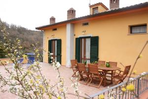 a patio of a house with a table and chairs at Casa Caldesi in Castiglion Fiorentino