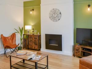 a living room with a coffee table and a tv at Hulne House in Alnwick