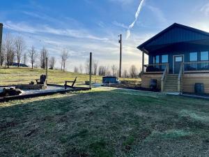 a small house with a yard next to a field at Bourbon Barrel Cottages #1 of 5 on Kentucky trail in Lawrenceburg