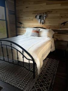 a bedroom with a bed with a wooden wall at Bourbon Barrel Cottages #1 of 5 on Kentucky trail in Lawrenceburg