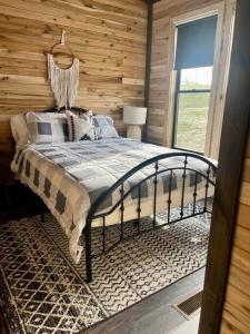 1 dormitorio con 1 cama con pared de madera en Bourbon Barrel Cottages #1 of 5 on Kentucky trail en Lawrenceburg