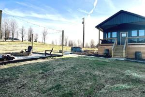 a house with a bench next to a grass field at Bourbon Barrel Cottages #1 of 5 on Kentucky trail in Lawrenceburg