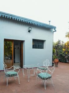 un patio con sillas, una mesa y un edificio en Lo de Poujade en Posadas