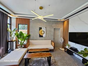 sala de estar con sofá y TV de pantalla plana en Obra Maestro Private Resort, en Lubao