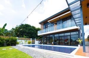 una casa con piscina frente a ella en Obra Maestro Private Resort, en Lubao