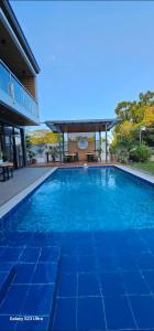 una gran piscina azul frente a una casa en Obra Maestro Private Resort, en Lubao