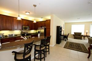 IT289 - Vista Cay Resort - 3 Bed 2 Baths Condo في أورلاندو: مطبخ وغرفة معيشة مع طاولة وكراسي