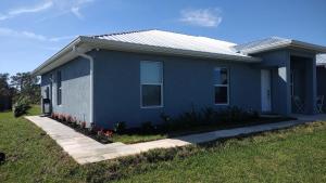 a blue house with flowers in front of it at The Orchard Suite of Sebring in Sebring