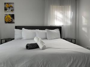 a white bed with a pair of towels on it at Four Bedroom Home Near Hartsfield Jackson Airport in Riverdale