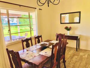 a dining room with a wooden table and a window at Bellevue Berg Cottage in Bergville
