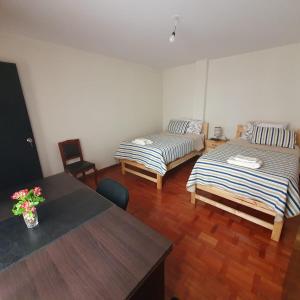 a room with two beds and a table at Departamento céntrico - 3 habitaciones in Sucre