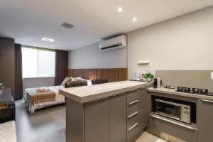 Habitación con cocina y dormitorio con cama. en Loft de Luxo no melhor ponto de Copacabana, en Río de Janeiro