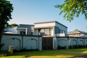 una casa azul con una valla delante de ella en Golfview luxury apartment en Richards Bay