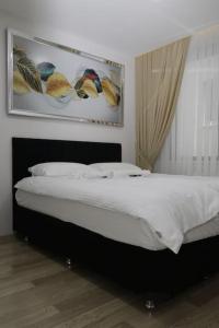 een slaapkamer met een bed met een foto aan de muur bij Fully Equipped Apartment Istanbul (Zarif26) in Avcılar