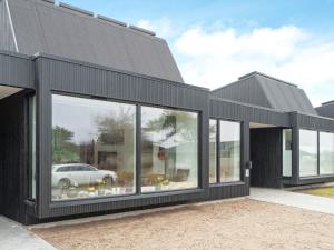 une maison noire avec de grandes fenêtres et une voiture dans l'établissement Holiday home Gilleleje VII, à Gilleleje