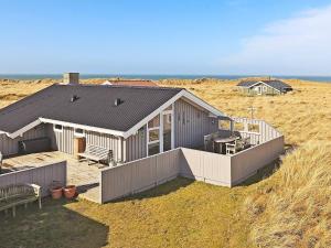a house sitting on top of a sandy beach at 4 person holiday home in Hjørring in Hjørring