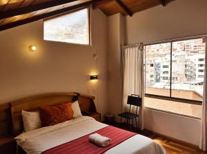 ein Schlafzimmer mit einem Bett und einem großen Fenster in der Unterkunft Eco Bunnu Inn in Cusco