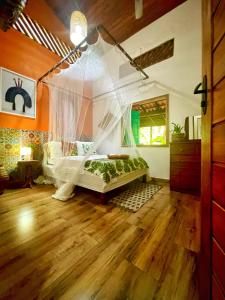 a bedroom with a bed with a mosquito net at CASA DA ARVORE, sonho na Amazônia, 2min a pé da praia in Alter do Chao