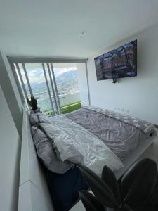 a bedroom with a bed and a large window at PENHOUSE (40 Floor) to enjoy the VIEW OF THE CITY! in Itagüí