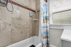 ein Badezimmer mit Badewanne und Duschvorhang in der Unterkunft Orlando Oasis! Free Laundry & Parking Near Disney! in Orlando + 30 Fotos