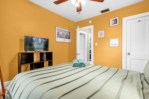 ein Schlafzimmer mit großem Bett und Flachbildfernseher in der Unterkunft Orlando Oasis! Free Laundry & Parking Near Disney! in Orlando