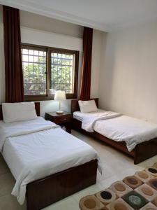 two beds in a room with two windows at شقق مرحبا المفروشة marhaba furnished apartment in Amman