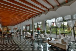 - un hall avec des canapés blancs, des tables et des fenêtres dans l'établissement aNhill Boutique, à Hue