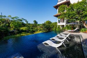 a pool with a row of boats in the water at aNhill Boutique in Hue