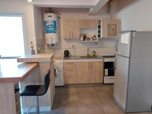 een keuken met een witte koelkast en houten kasten bij ALTOURQUIZA8 in Guaymallen