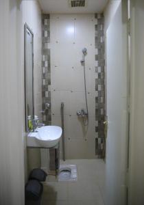 y baño con ducha, lavamanos y ducha. en Modern Apartment, en Al Rass
