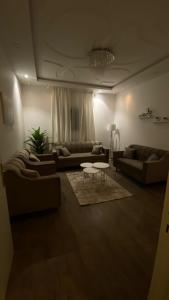 a living room with couches and a table in it at شقة جديدة ومفروشة للايجار اليومي والشهري في محافظة الرس in Ar Rass