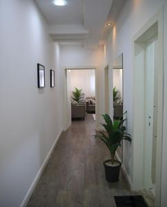 un pasillo con paredes blancas y una maceta en Modern Apartment, en Al Rass