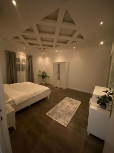 a bedroom with a large bed and two tables at شقة جديدة ومفروشة للايجار اليومي والشهري في محافظة الرس in Ar Rass