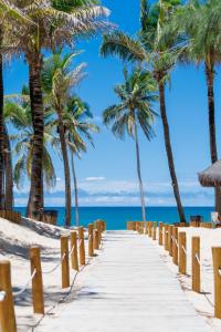 un chemin sur la plage avec des palmiers dans l'établissement VG Sun Cumbuco Sea Breeze Vista Mar, à Cumbuco