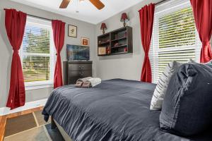 1 dormitorio con cortinas rojas, 1 cama y TV en Orlando Oasis! Free Laundry & Parking Near Disney! en Orlando