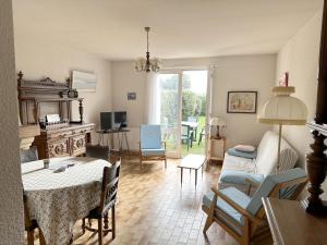 uma sala de estar com mesa e cadeiras e uma sala de estar em Maison Arzon, 3 pièces, 4 personnes - FR-1-639-91 em Arzon
