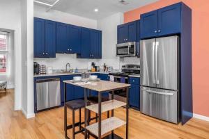 a kitchen with blue cabinets and a small island at Welcome to The Charming High st Suites in West Chester