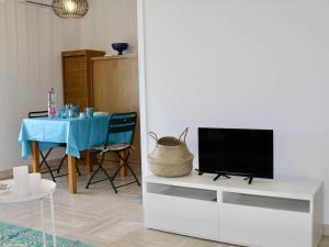 - un salon avec une télévision sur un centre de divertissement blanc dans l'établissement Appartement Villeneuve-Loubet, 1 pièce, 2 personnes - FR-1-252A-99, à Villeneuve-Loubet