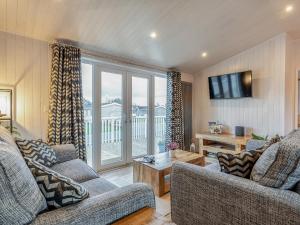 a living room with two couches and a television at Heather Lodge in Willington