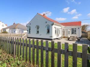 a white house behind a wooden fence at Senafe in Bude