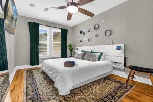 a bedroom with a white bed and a ceiling fan at Orlando Oasis! Free Laundry & Parking Near Disney! in Orlando