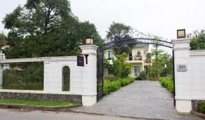 una entrada a una casa blanca con una puerta en L'âme - The Hideaway, en Thôn Dương Xuân Hạ