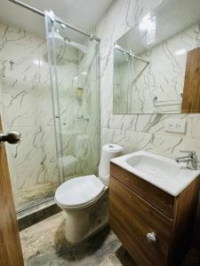 een badkamer met een toilet, een wastafel en een douche bij Aparta estudio cerca al aeropuerto el Dorado in Bogota