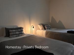 - deux lits assis l'un à côté de l'autre dans une pièce dans l'établissement Homestay - Yarra River Boulevard, à Melbourne