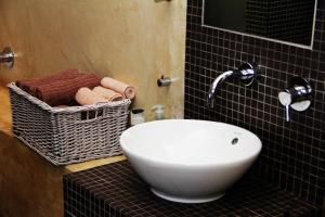 a bathroom with a sink and a basket of towels at Apt 67 Long Street no loadshedding in Cape Town +38 photos